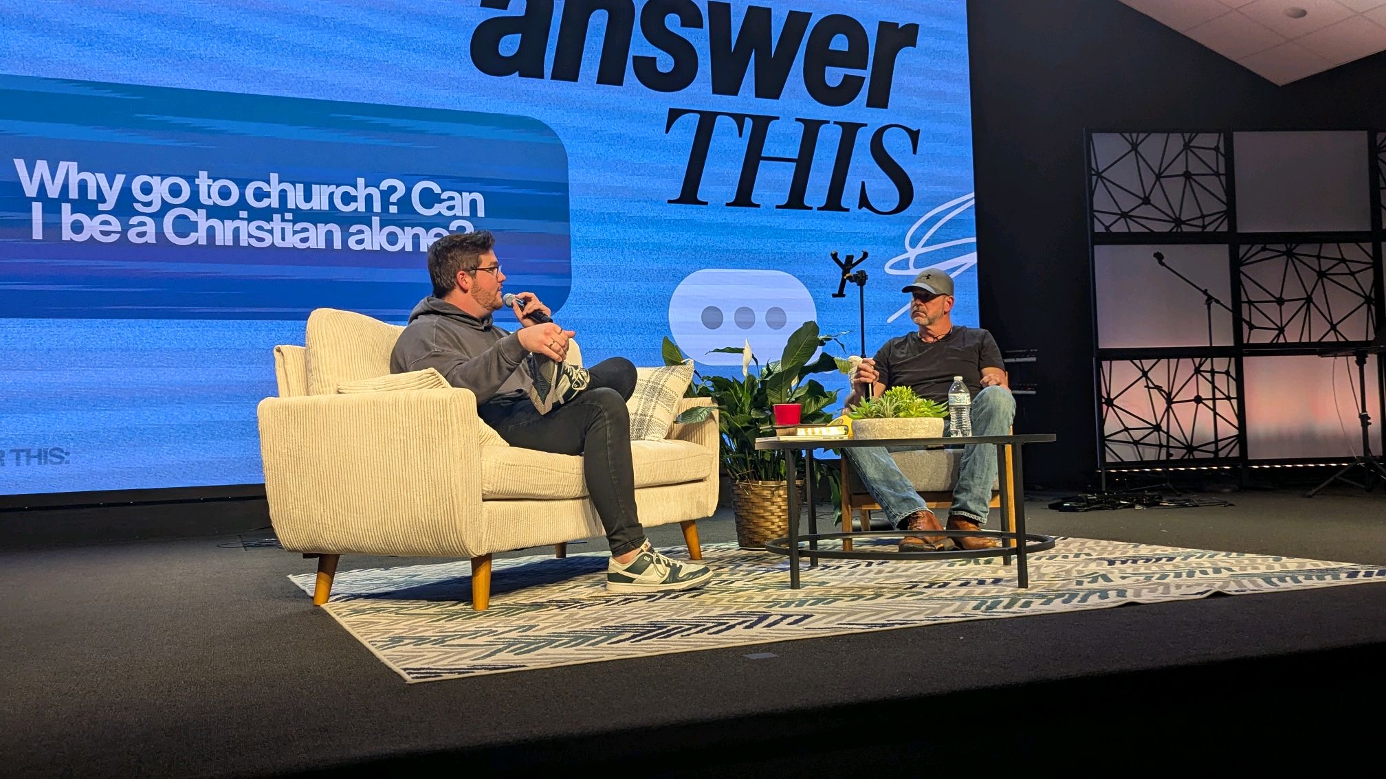 Dylan speaking into a microphone during an Answer This conversation at Open Door Youth